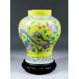 A Chinese yellow ground porcelain baluster-shaped vase enamelled in colours with flowering