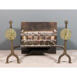 A wrought iron and brass fire grate with front andiron supports and cast brass circular panels,