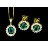 A pair of modern 18k emerald and diamond earrings (for pierced ears), the oval cut emerald of
