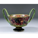 An early Moorcroft pottery two-handled kylix decorated in colours with "Spanish" pattern, on a green