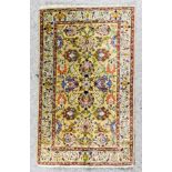A Tabriz rug woven in colours with bold palmettes and trailing floral ornament, on old gold