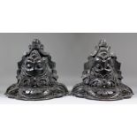 A pair of 19th Century stained oak wall brackets carved with moustachioed male masks, 13.75ins