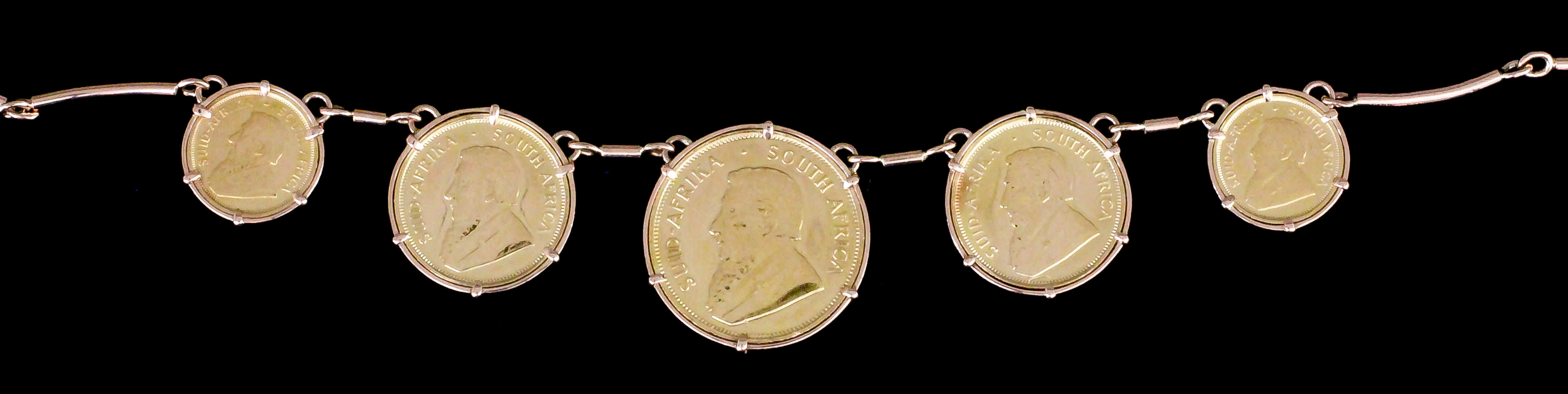 A modern 9ct rose gold bar link necklace hung with South African 1980 Half Krugerrand, two 1981
