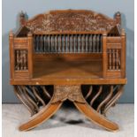 An early 20th Century Indian hardwood howdah chair, the shaped cresting carved with floral and