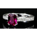 A modern 18k white gold mounted ruby and diamond ring, the cushion cut ruby of 1.2ct, shouldered
