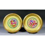 A pair of Royal Worcester bone china circular plaques enamelled in colours with floral sprays and