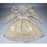 An early Victorian child's dress in pale mauve and cream diamond pattern French percale, with
