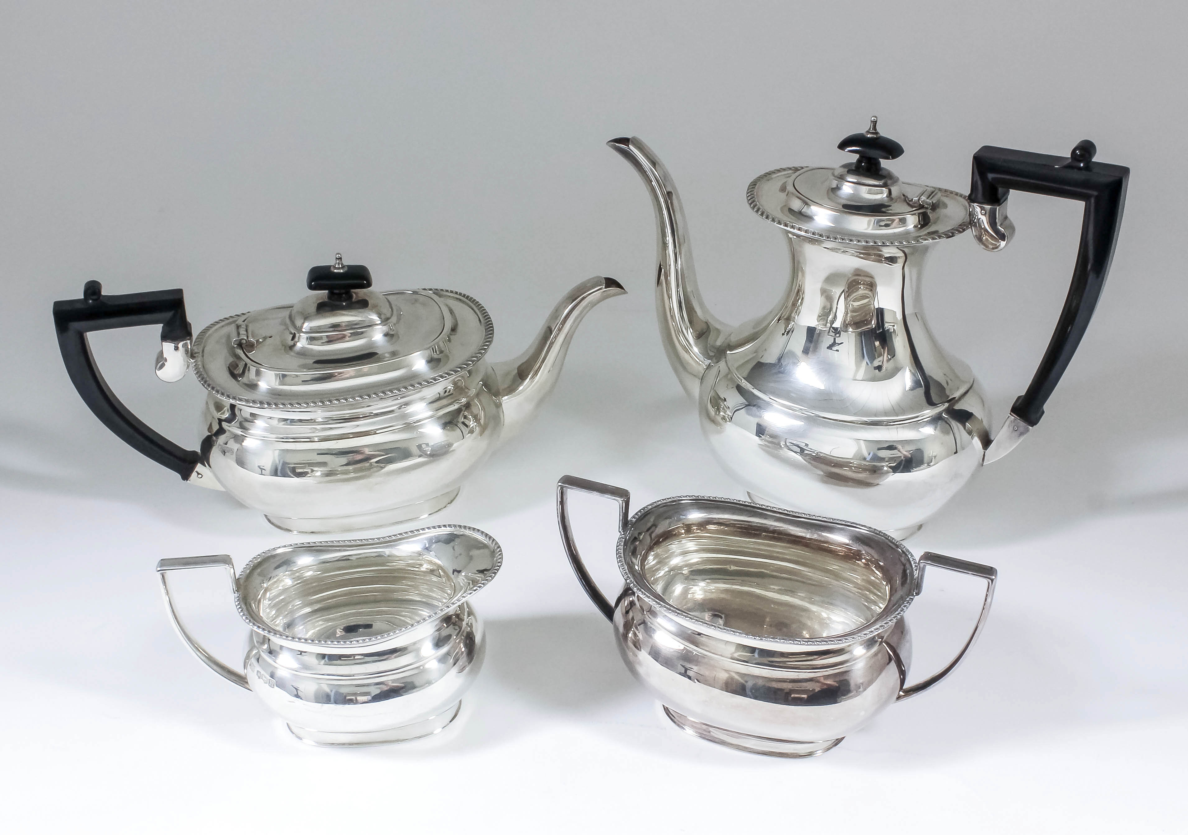 An Elizabeth II silver rectangular four piece tea and coffee service with gadroon mounts, ebonised