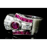 An Art Deco 18ct white gold mounted ruby and diamond ring, the circular cut collet set central
