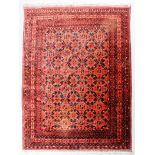 A Turkmen carpet woven in navy blue, rose, fawn and ivory with trellis design of lozenge motifs,