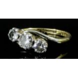 A modern 18ct gold and platinum mounted three stone diamond ring, the central brilliant cut stone of