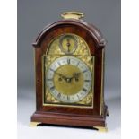 A late 19th Century mahogany cased mantel clock of "George III" design, the 7ins arched brass dial