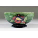 A Moorcroft pottery bowl, tubelined and decorated in colours with "Orchid" design on green ground,