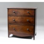 A late Georgian mahogany miniature chest, fitted three drawers, with shaped apron and bracket