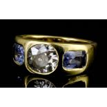 An Edwardian 18ct gold mounted three stone diamond and sapphire gypsy set ring, the central oval cut