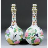 A pair of Japanese porcelain bottle vases and stoppers, each enamelled in gilt with birds amongst