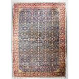 An Isfahan carpet woven in colours with a bold floral filled Herati design, on a navy blue ground,