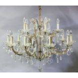 A gilt metal moulded and cut glass twelve light electrolier, the central column with bulbous