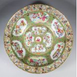 A Chinese porcelain "Cantonese" punch bowl, typically enamelled with figures within shaped