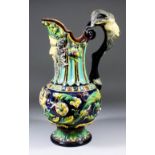 A 19th Century Continental majolica ewer moulded with two Putti supporting a cartouche, acanthus