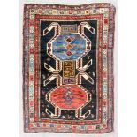 A Kazak rug of "Lenkoran" design woven in colours with two bold hooked motifs and birds, on a dark