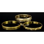 Two modern Eastern gold coloured metal stiff pattern bangles with engraved faces (gross weight 30.