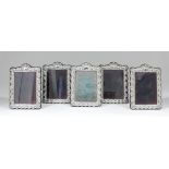 Five Elizabeth II silver rectangular photograph frames of shaped outline, embossed with vacant