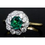 A modern 18ct gold mounted emerald and diamond flowerhead ring, the central cushion cut emerald