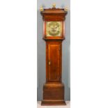 An 18th Century oak longcase clock by Thomas Wolley of Charing, the 12ins square brass dial with