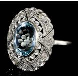 A modern silvery coloured metal mounted aquamarine and diamond set ring, the oval cut aquamarine