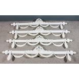 Four Anglo-Indian cream and white painted wood overdoor poles of reeded form, with ribbon