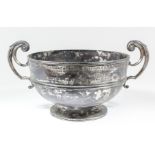 A late Victorian silver circular two-handled bowl with moulded rim and girdle, high leaf capped C-