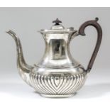 An Edward VII silver oval coffee pot with gadroon mounts, part reeded body, ebonised finial and C-