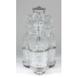 A plated spirit cruet with hoop handle and shaped base 13.75ins high and with three cut glass