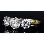 A modern 18ct gold mounted three stone diamond ring, central brilliant cut stone of .92ct shouldered