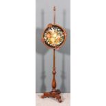 A Victorian mahogany pole screen the circular panel with scroll and fan carved frame and inset
