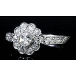 A modern 18ct white gold mounted all diamond set flowerhead pattern ring, face and shoulders set