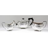 An Edward VII silver rectangular three piece tea service with gadroon mounts, moulded bodies,