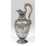 A Victorian silver urn pattern water jug with shaped and moulded rim, cane covered handle with