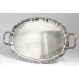 An Edward VIII silver oval two-handled tray of shaped and moulded outline and with shaped handles,