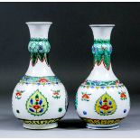 An associated pair of Chinese porcelain "Famille Verte" garlic-neck bottle vases, each enamelled