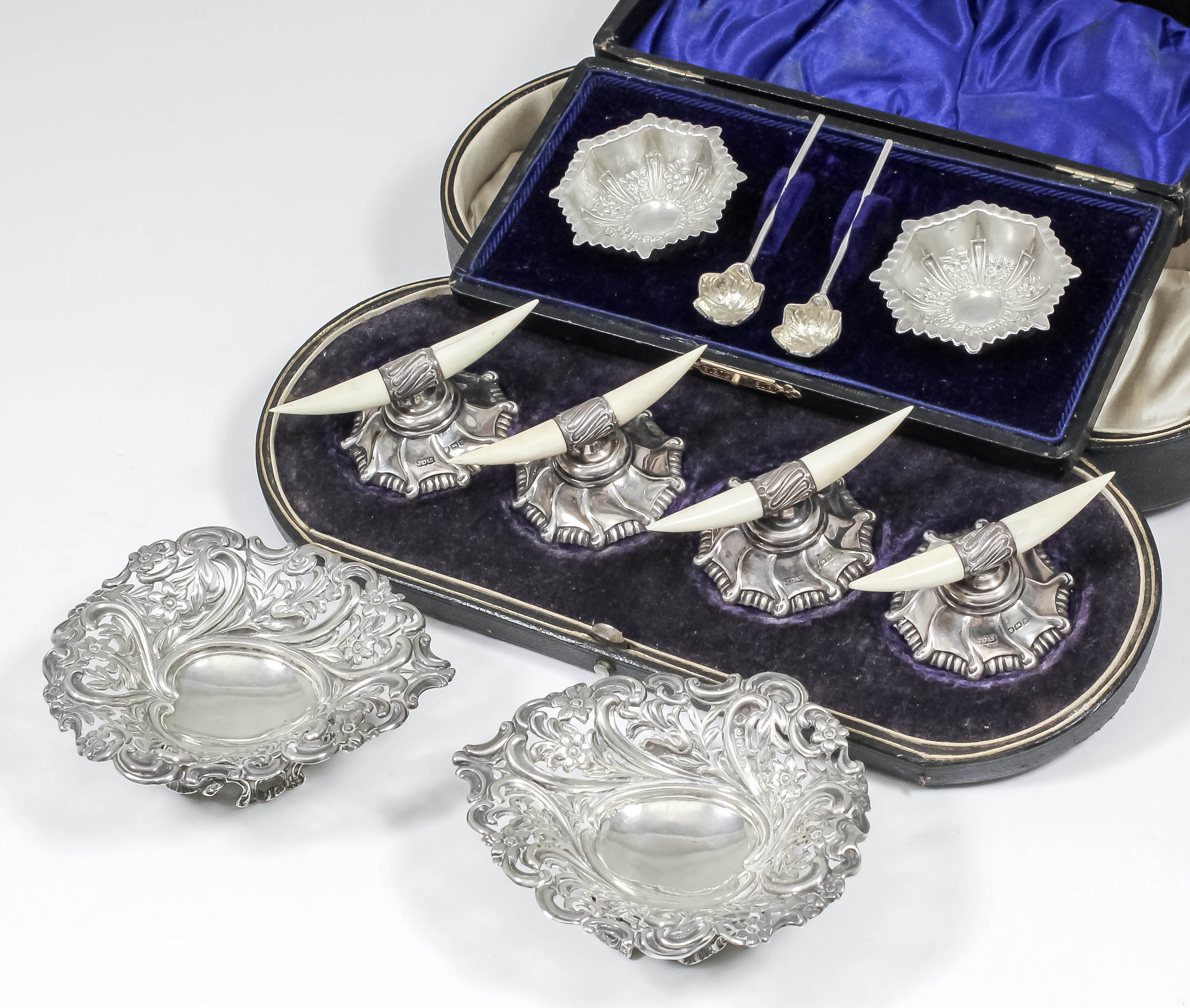 A set of four Edward VII silver and ivory tusk pattern knife rests, on shaped bases with bead