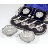 A set of four Edward VII silver and ivory tusk pattern knife rests, on shaped bases with bead