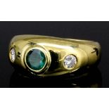 A modern 18ct gold mounted emerald and diamond ring, the central circular collet set emerald of