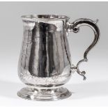 A George III silver baluster-shaped tankard with moulded rim and footrim and with leaf capped double