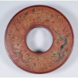 A Chinese red lacquer circular ring box, the lid decorated with three five clawed dragons, on a