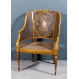 A late 19th Century painted satinwood tub-shaped Bergere armchair, the shaped back with oval
