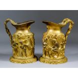 A pair of 19th Century Continental gilt metal jugs moulded in relief with a bacchanalian scene of