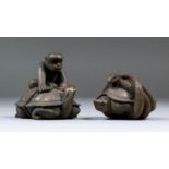 A Japanese carved boxwood netsuke of a monkey astride a turtle tying a knot in a rope, the