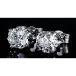 A pair of silvery coloured metal mounted diamond solitaire earrings (for pierced ears), the